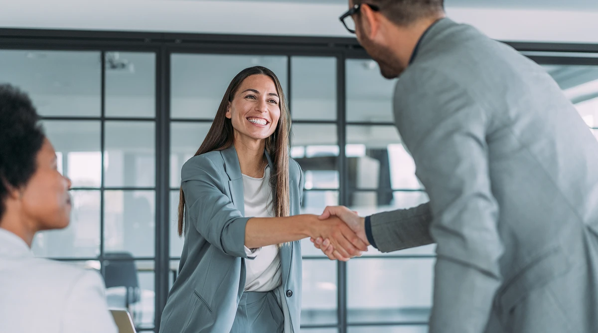 picture of a businesswoman & businessman shaking hands in an office